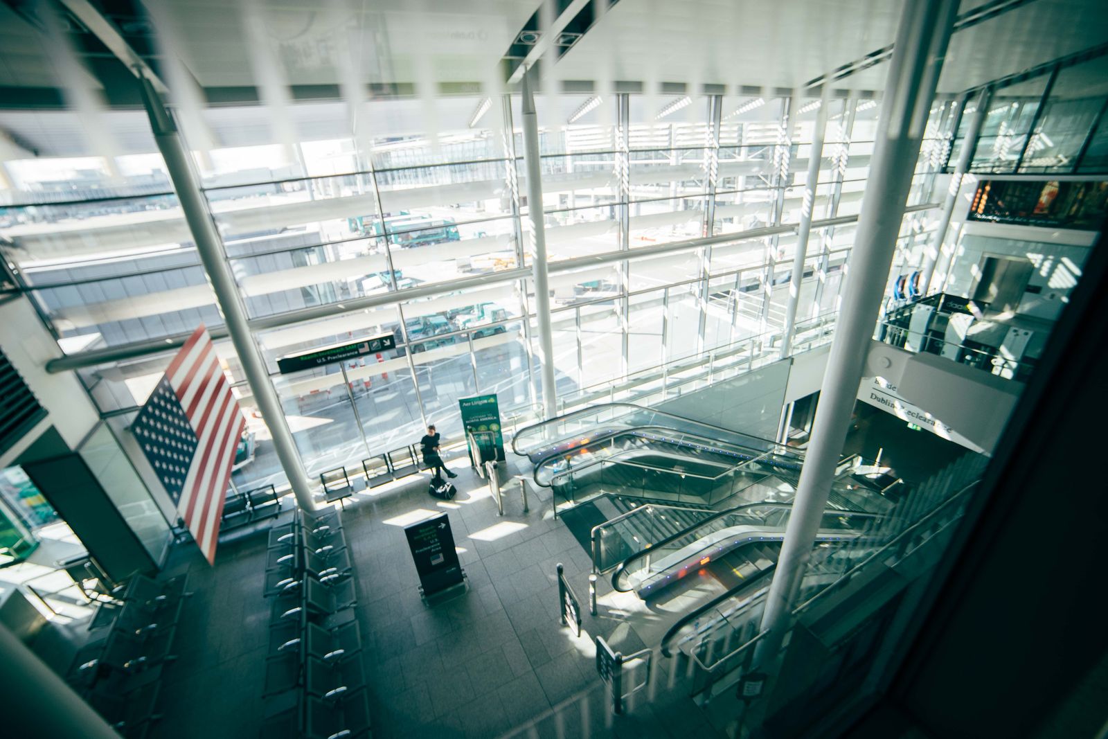 Bright spacious airport terminal with glass walls and escalators