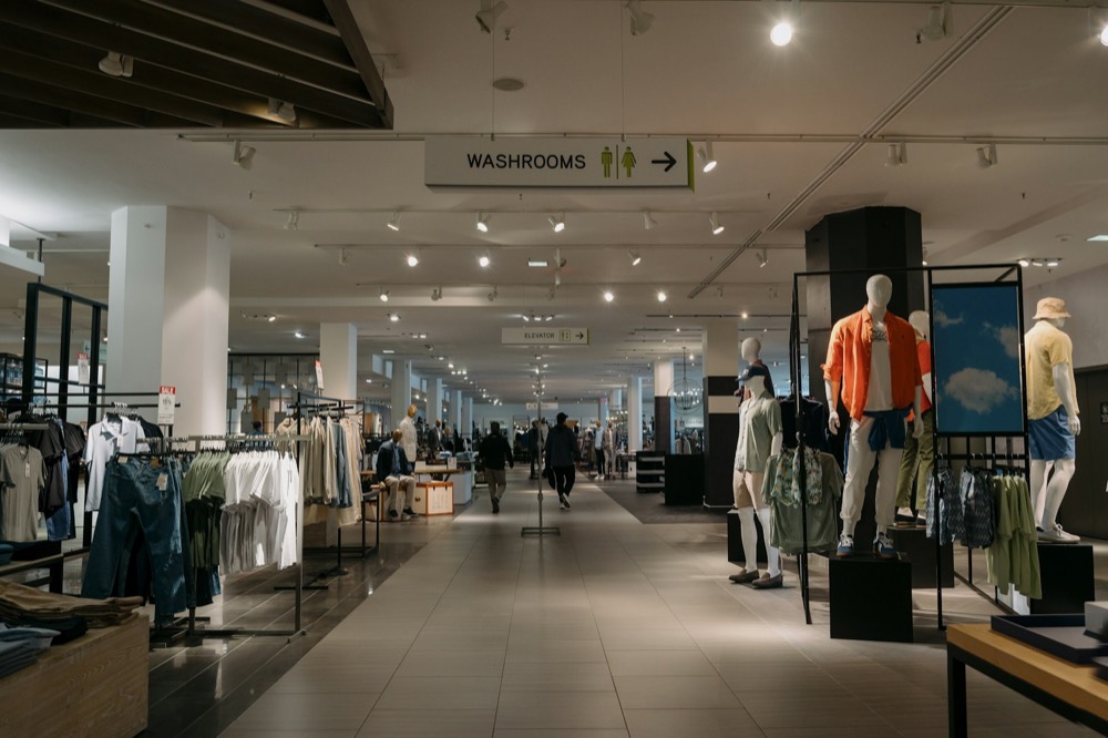 Bright modern retail store aisle with clothing and signage