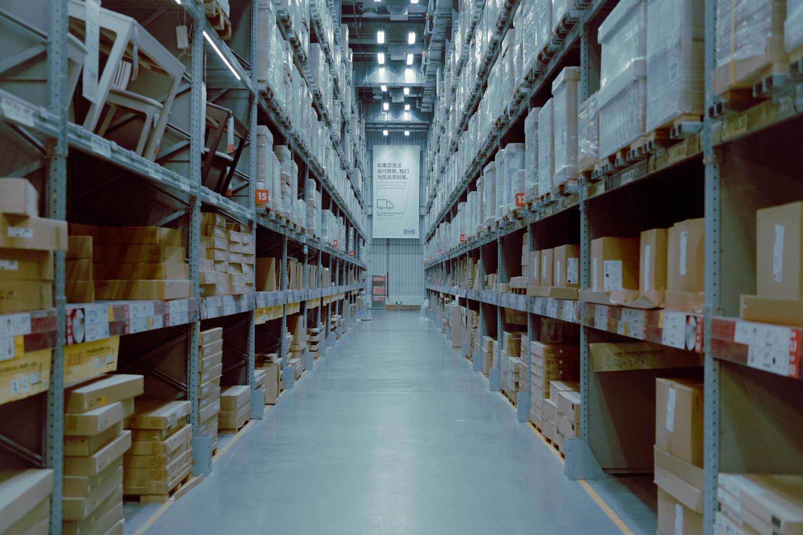 Warehouse aisle with tall shelving stacked with boxes